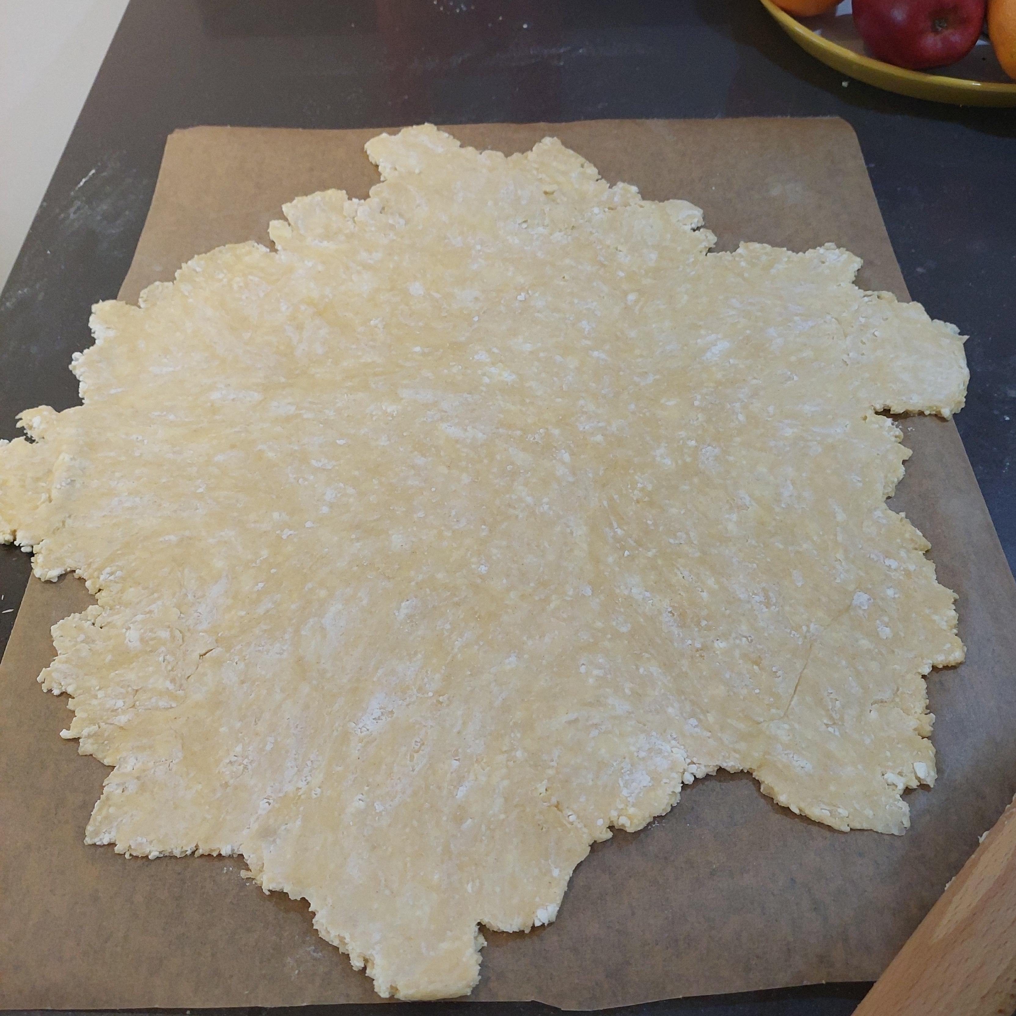 On the baking paper, roll out the dough until it's about half centimetre thick. Sprinkle a bit of flour to prevent the dough from sticking to the rolling pin.