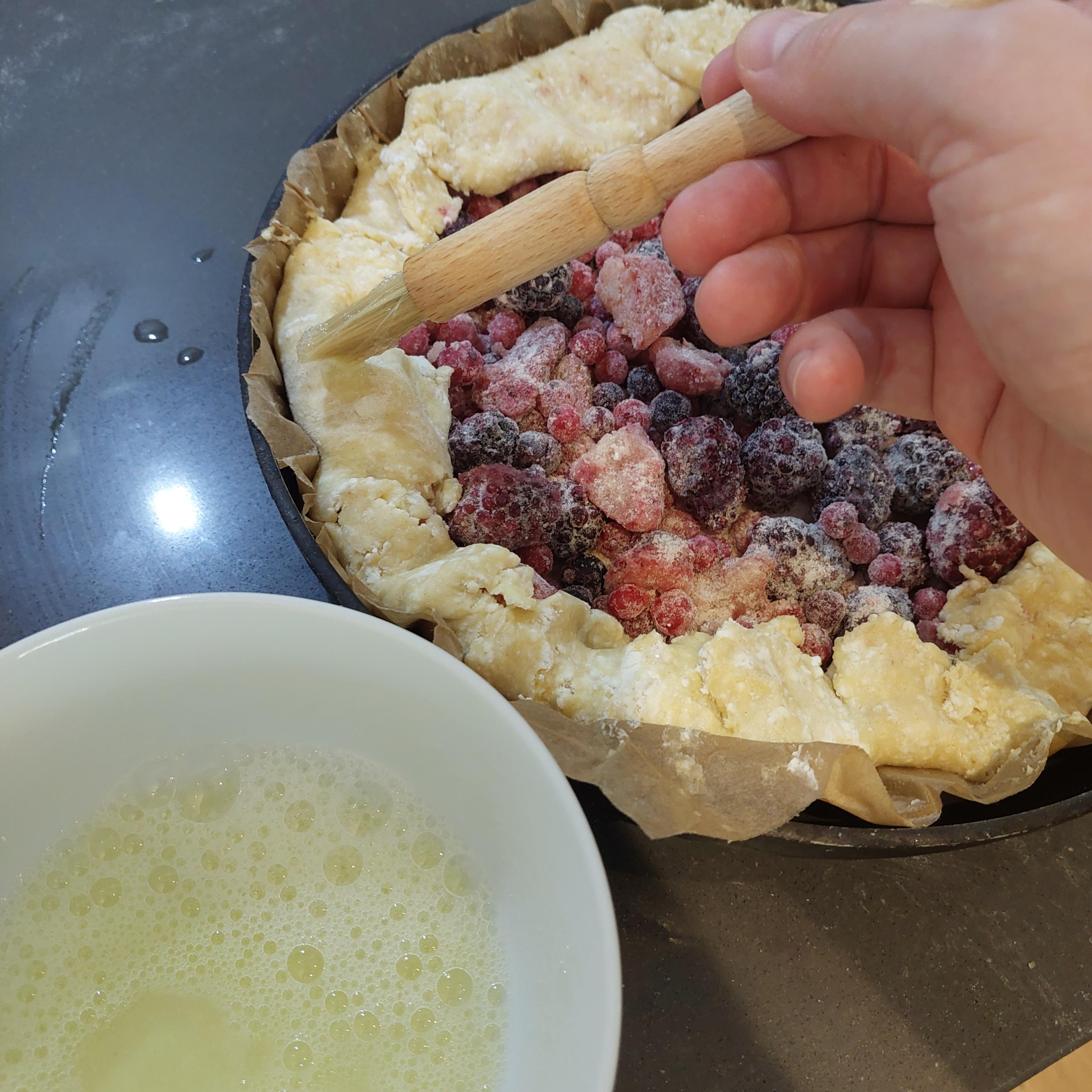 Brush whisked egg white over the dough.